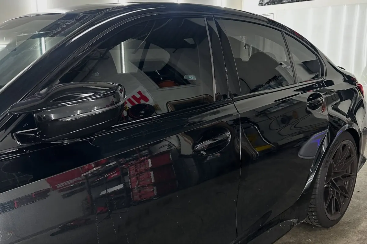 Black BMW sedan featuring dark window tinting.